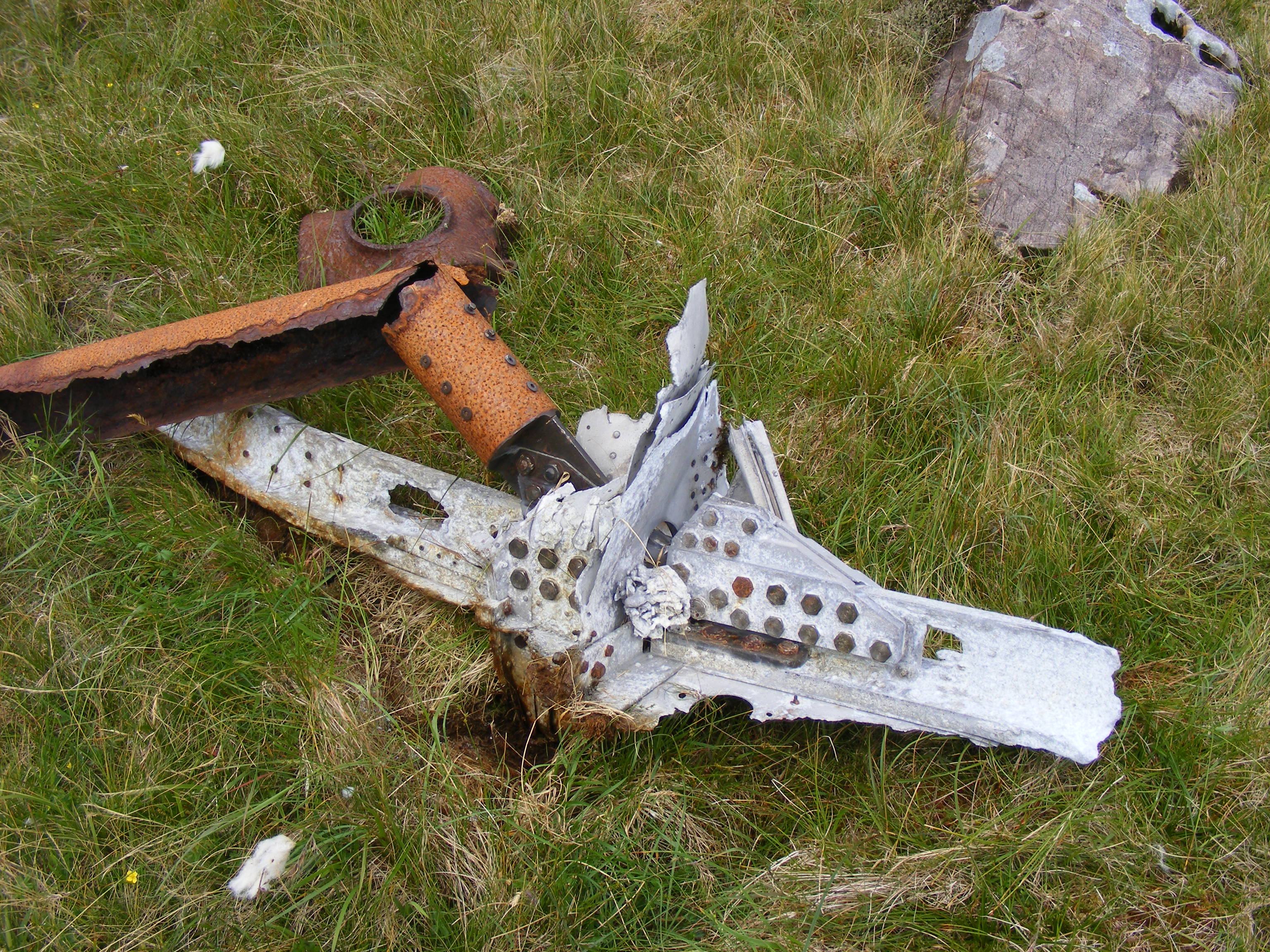 A piece of aircraft structure in the grass next
              to the rocks.